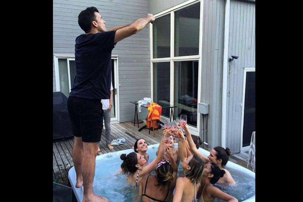 Man crouching at an awkward angle to photograph his girlfriend for Instagram