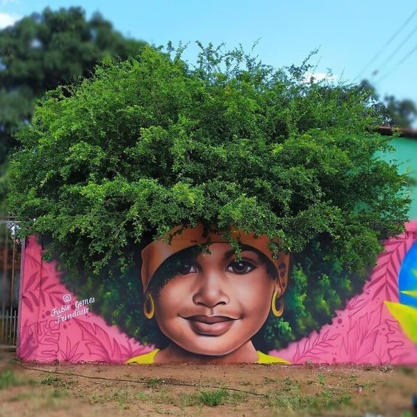 Street art mural of a woman using a tree’s leaves as her hair