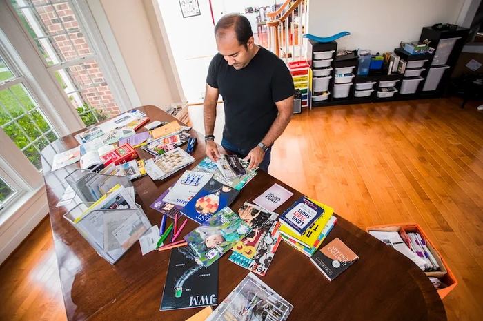 Rohit sorting printed research across a table
