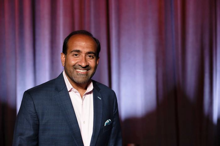 Headshot: Rohit in a blue suit and pink shirt