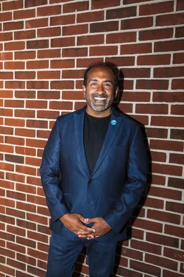 Headshot: Rohit against a brick wall, vertical
