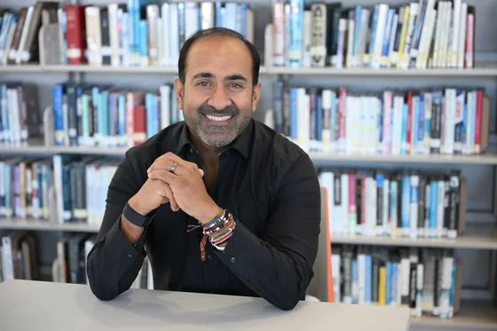 Headshot: Rohit sitting in a library