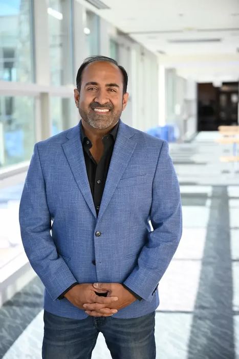 Headshot: Rohit standing in a suit, vertical