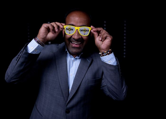 Rohit Bhargava holding up a pair of yellow Non-Obvious glasses and laughing